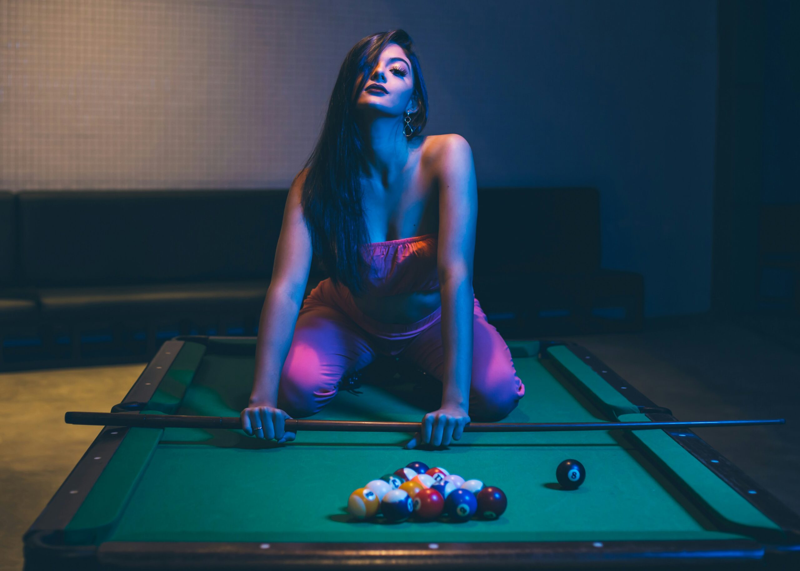 Nassau Escort woman posing by pool table